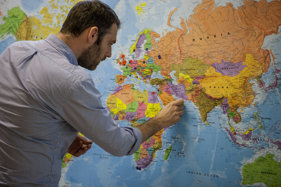 A man at work pinning points onto a map