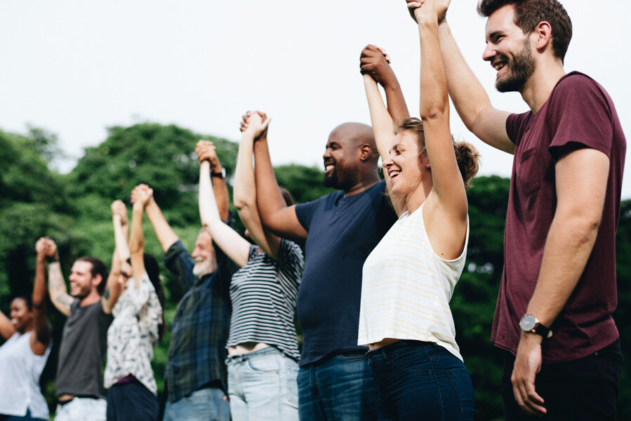 People raising held hands stood in a line together