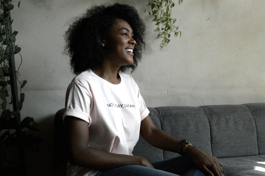 A woman sat on a sofa looking relaxed and smiling